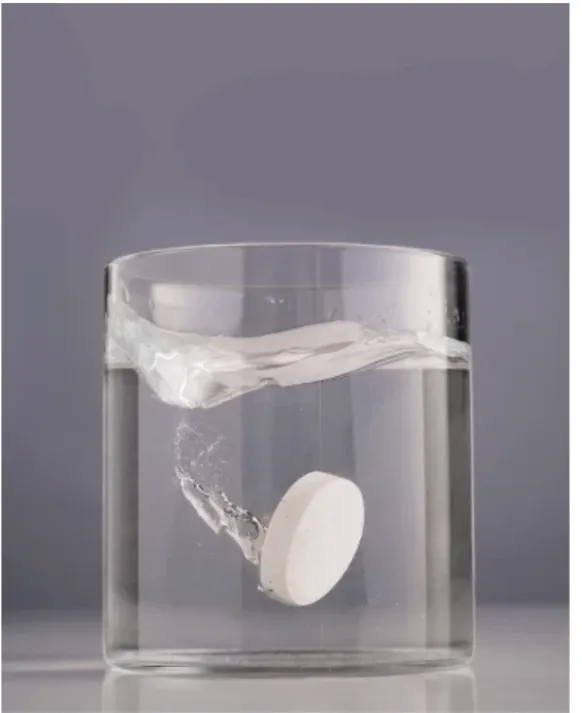 A JUJU tablet dropping into a glass of water