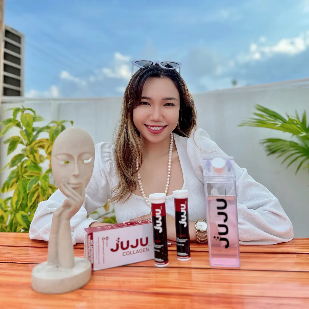 Smiling woman with JUJU collagen tubes, box and bottle