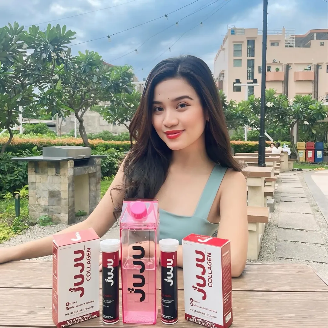 Woman at a table with JUJU collagen boxes and a water bottle