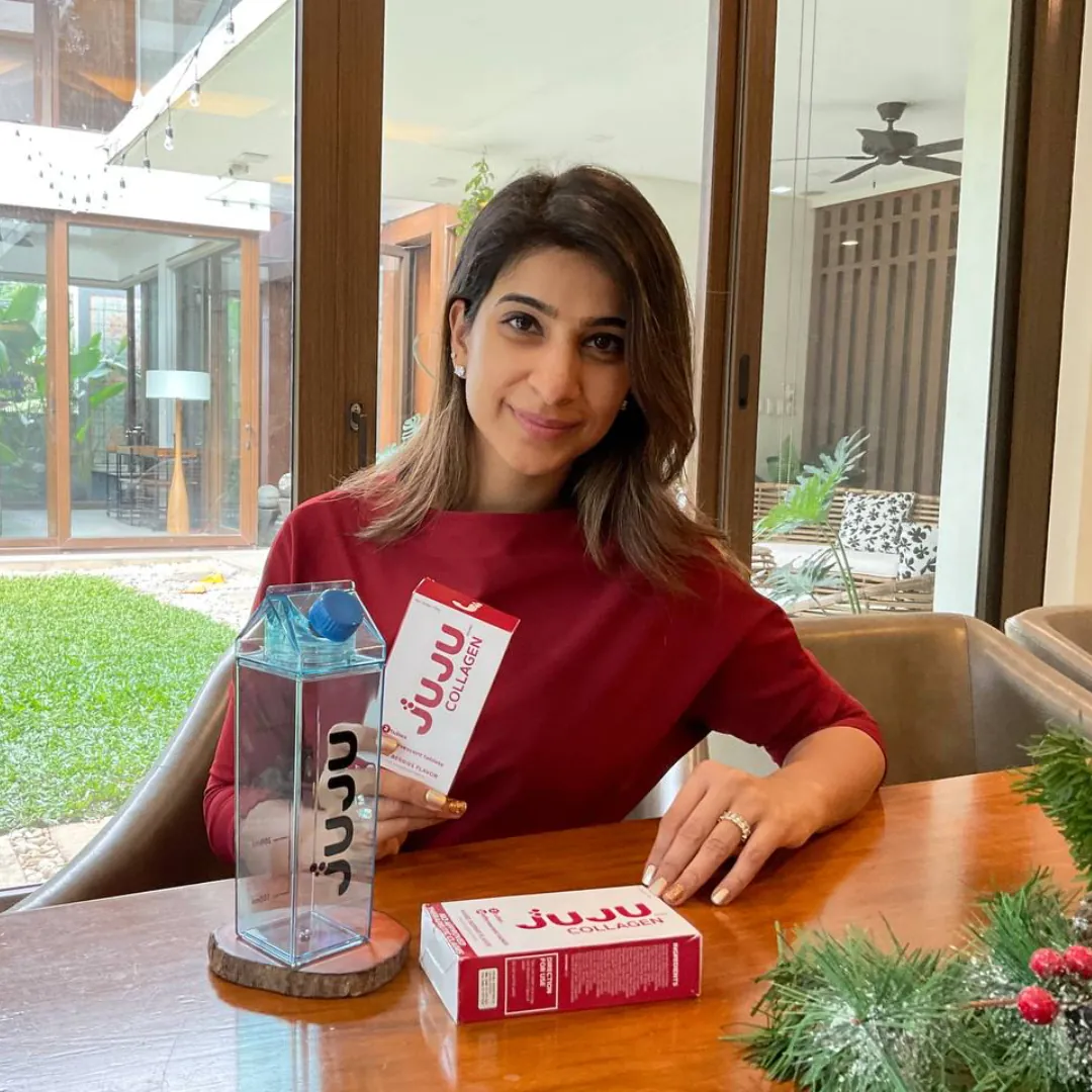 Woman with JUJU boxes, tubes and a bottle of pink collagen drink
